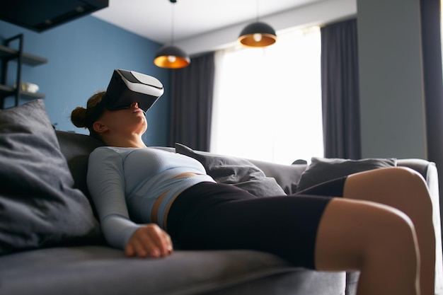 Mulher em óculos de realidade virtual entra na experiência imersiva do metaverso através da interface do fone de ouvido descansando