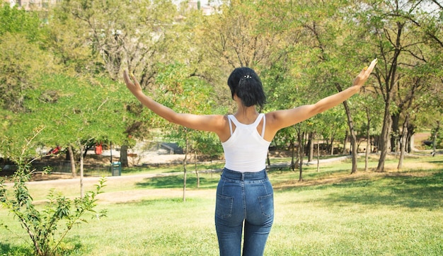 Mulher em pé na natureza com as mãos abertas