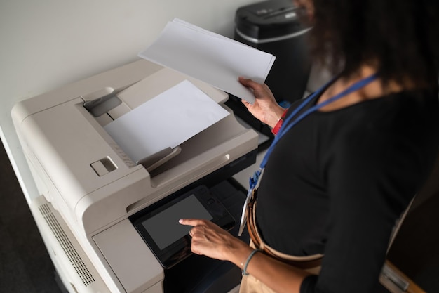 Mulher em pé perto da xerox no escritório