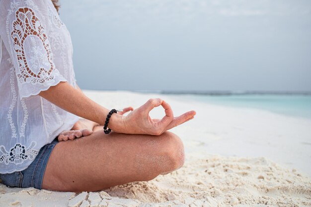 mulher em postura de meditação junto ao mar