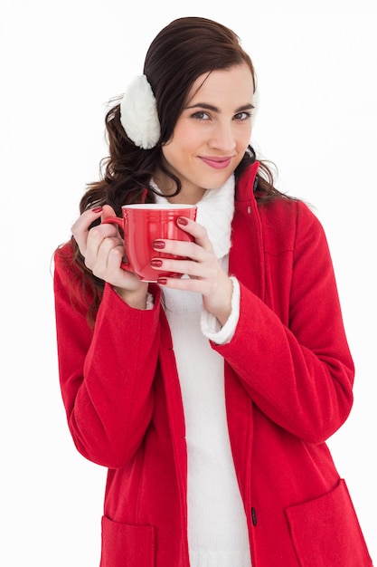 Mulher em roupas de inverno segurando uma caneca