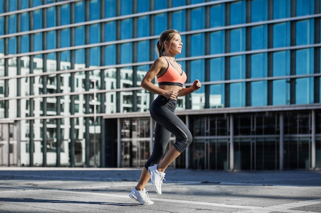 Mulher em roupas esportivas correndo na cidade