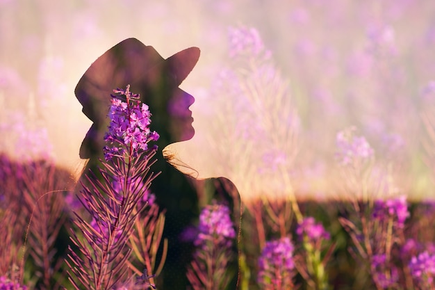 Foto mulher em silhueta de chapéu no campo de flores de verão desabrochando sally.