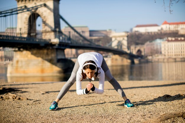 Mulher, em, sportswear, esticar, ligado, danúbio, rio, promenade, em, budapest