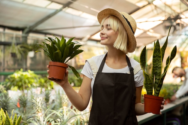 Foto mulher em tiro médio segurando vasos de plantas