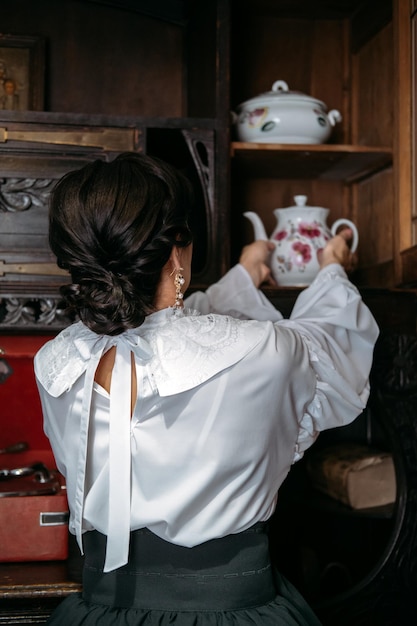 Foto mulher em traje de blusa vintage em velhos vestidos históricos interiores roupas vintage