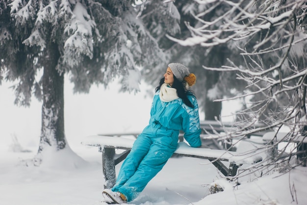 Mulher em traje de esqui na floresta de neve durante as férias de inverno ao ar livre