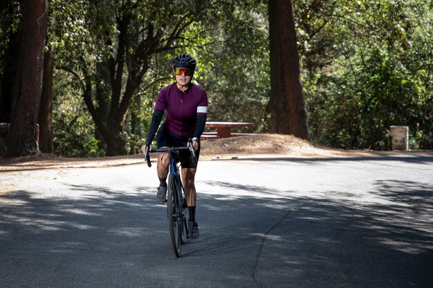Mulher em trilha de bicicleta em uma estrada no meio do conceito de esporte ao ar livre na floresta