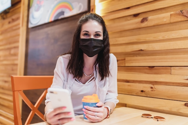 Mulher em um café em quarentena. Foto de alta qualidade