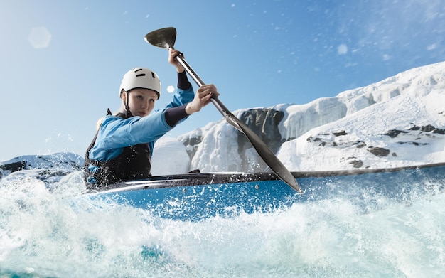 Mulher em um caiaque navega em um rio de montanha Whitewater caiaque extremo