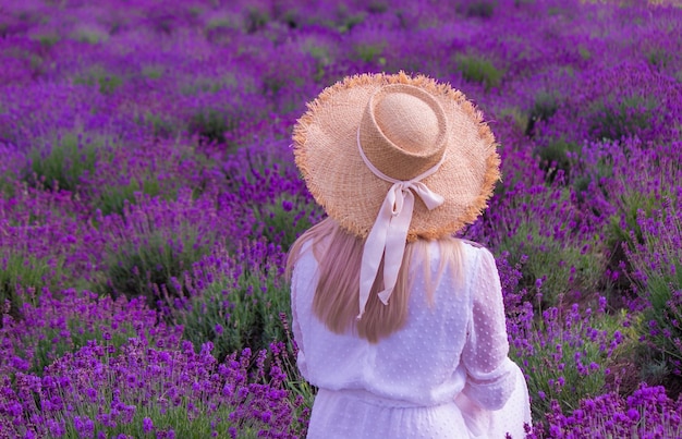 Mulher em um campo de flores de lavanda em um vestido branco Ucrânia