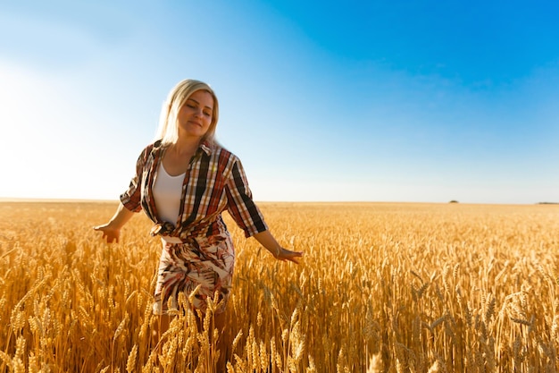 Mulher em um campo de trigo no fundo do sol poente