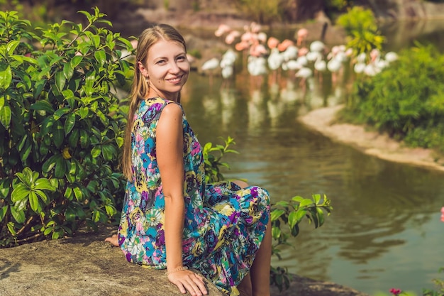 Mulher em um fundo de flamingos em um lago