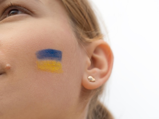 Mulher em um protesto com bandeira ucraniana azul e amarela na bochecha