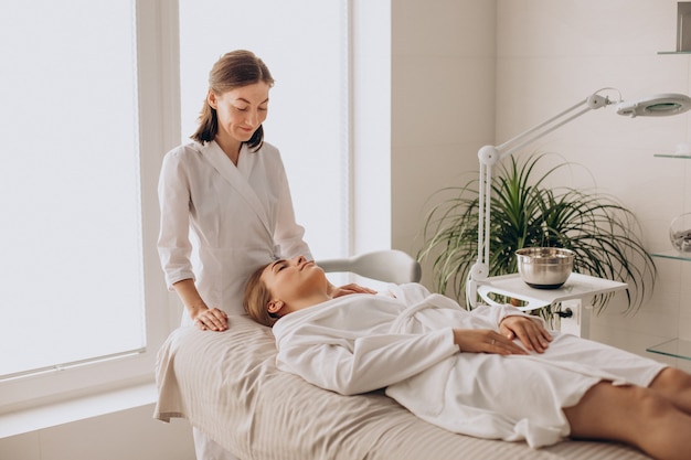 Mulher em um salão de beleza fazendo massagem no rosto e pescoço