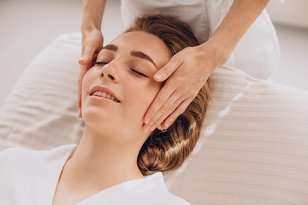 Foto mulher em um salão de beleza fazendo massagem no rosto e pescoço