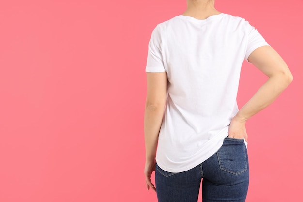 Mulher em uma camiseta branca em branco sobre fundo rosa