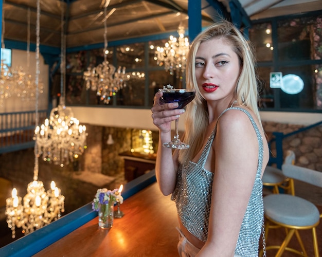 Mulher em uma casa colonial tomando um coquetel.