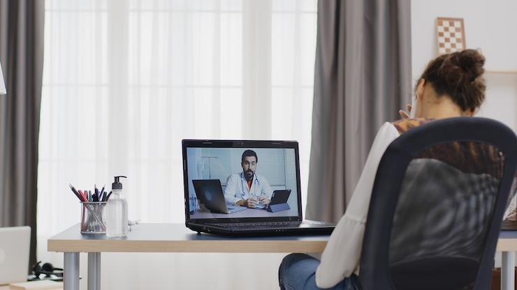 Foto mulher em uma videochamada remota com seu médico usando um computador tablet.