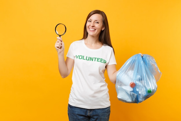 Mulher em voluntário de t-shirt, saco de lixo isolado em fundo amarelo. Ajuda de assistência gratuita voluntária, graça de caridade. Problema de poluição ambiental. Pare o conceito de proteção ambiental de lixo natural.