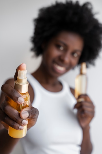 Foto mulher embaçada de tiro médio segurando produtos de cabelo