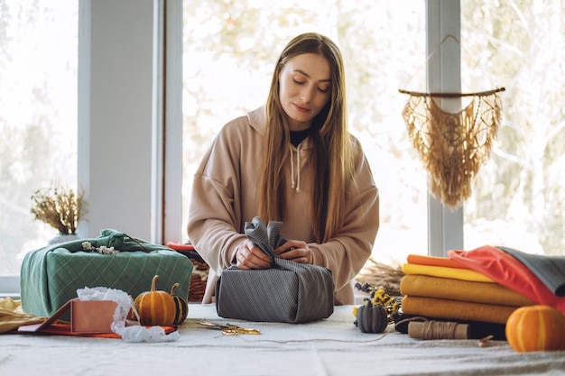 Mulher embrulha furoshiki para presente em estilo zero desperdício furoshiki japonês embrulho para presente de ação de graças zero