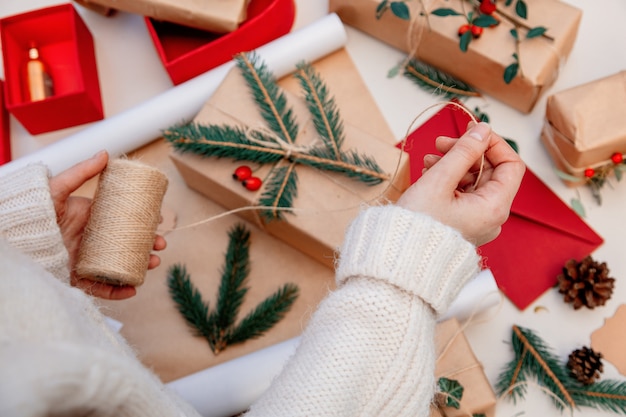 Mulher embrulhar um presente para um Natal em uma mesa