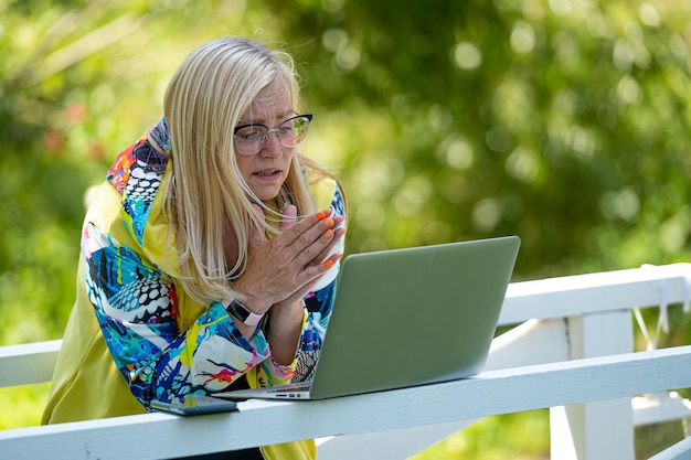 Mulher emocional com laptop fazendo videochamada e gesticulando ativamente o conceito de comunicação online