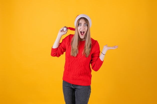 Mulher emocional usando chapéu de Papai Noel e camisola vermelha