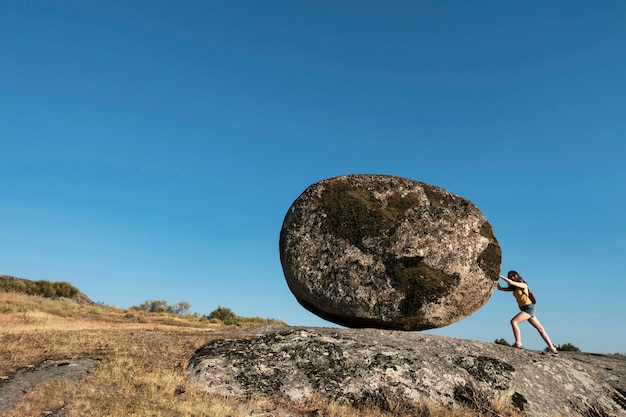 Foto mulher empurrando uma pedra do mundo.