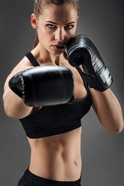 Mulher encantada posando com luvas de boxe