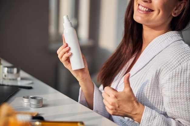 Mulher encantada positiva levantando o polegar