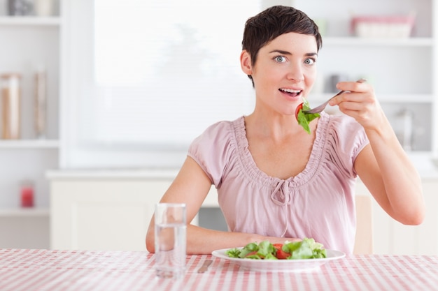 Mulher encantadora comendo salada