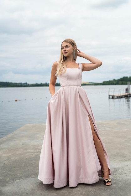 Mulher encantadora de fantasia em elegante vestido de noite de ping relaxante perto do horário de verão do lago