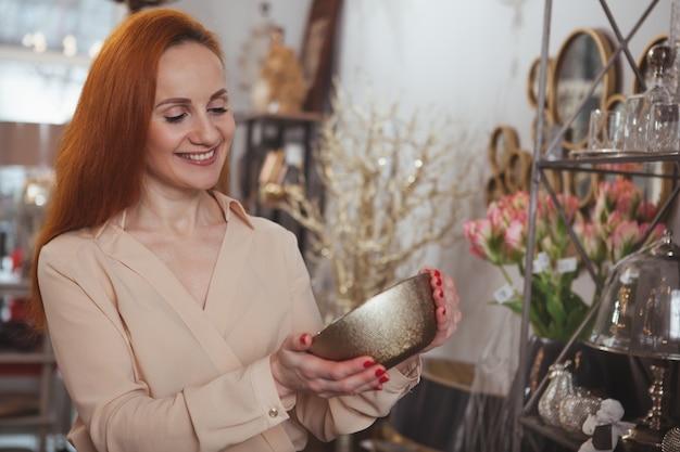 Mulher encantadora, desfrutando de compras na loja de decoração para casa