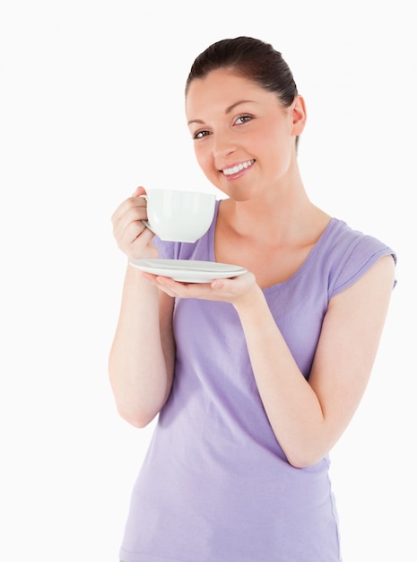 Mulher encantadora desfrutando de uma xícara de café enquanto está de pé