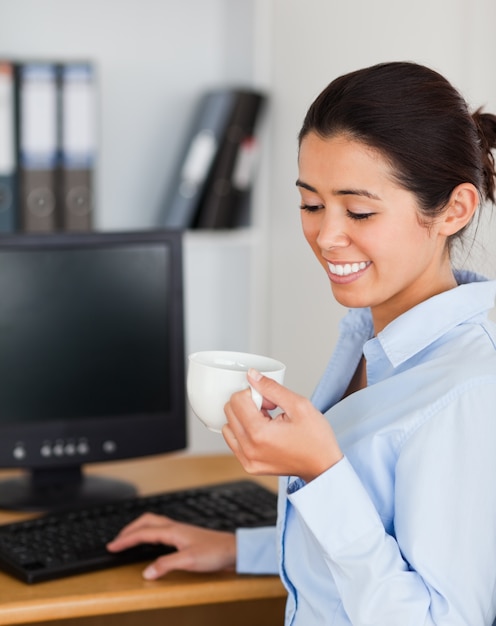 Mulher encantadora segurando uma xícara de café enquanto está sentado