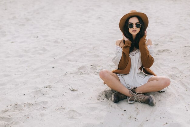 Mulher encantadora sentada na areia