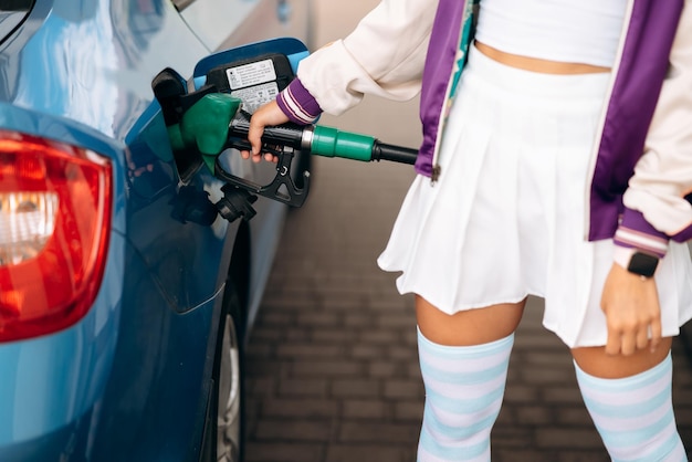 Mulher enchendo seu carro com combustível em um posto de gasolina