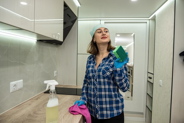 Mulher enérgica limpa cozinha com meios modernos de limpeza de sujeira em lugares inacessíveis