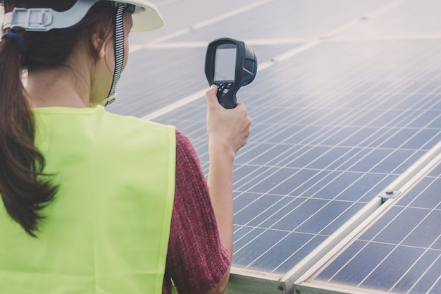 Mulher engenheiro usando termovisor para verificar o calor da temperatura do painel solar