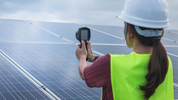 Mulher engenheiro usando termovisor para verificar o calor da temperatura do painel solar