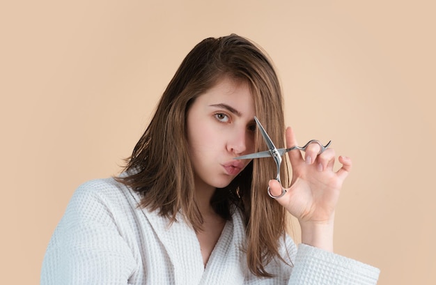 Mulher engraçada a cortar o cabelo com tesouras.