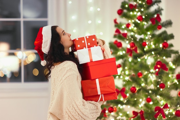 Mulher engraçada do papai noel com presentes em casa