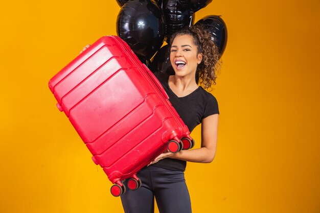 Foto mulher engraçada segurando uma bolsa de viagem pesada. aniversário de promoção de viagem. black friday em passagens aéreas.