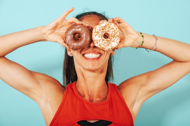 Foto mulher engraçada usa rosquinhas doces como óculos