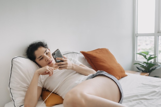 Mulher entediada usa a mídia social do smartphone para passar o tempo no apartamento