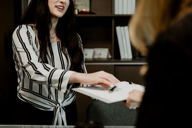 Mulher entregando o contrato ao cliente