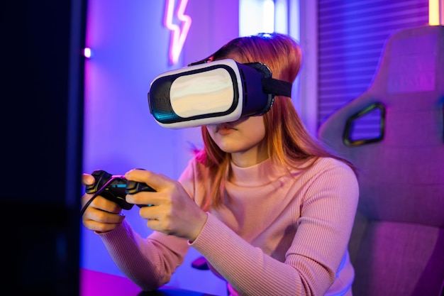 Mulher entusiasmada virtual jogando controlador de gamepad ela muito determinada em casa Jogador em óculos de fone de ouvido VR explorando o metaverso jogar videogame on-line com joystick nas luzes de néon do computador