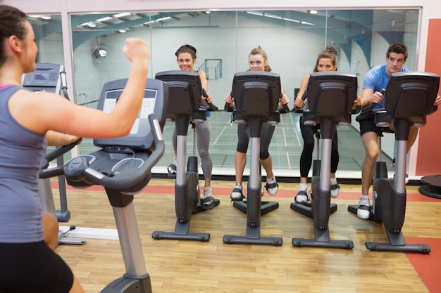 Mulher entusiasta ensinando aula de spinning